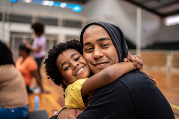 portrait of father and daughter embracing at a community center